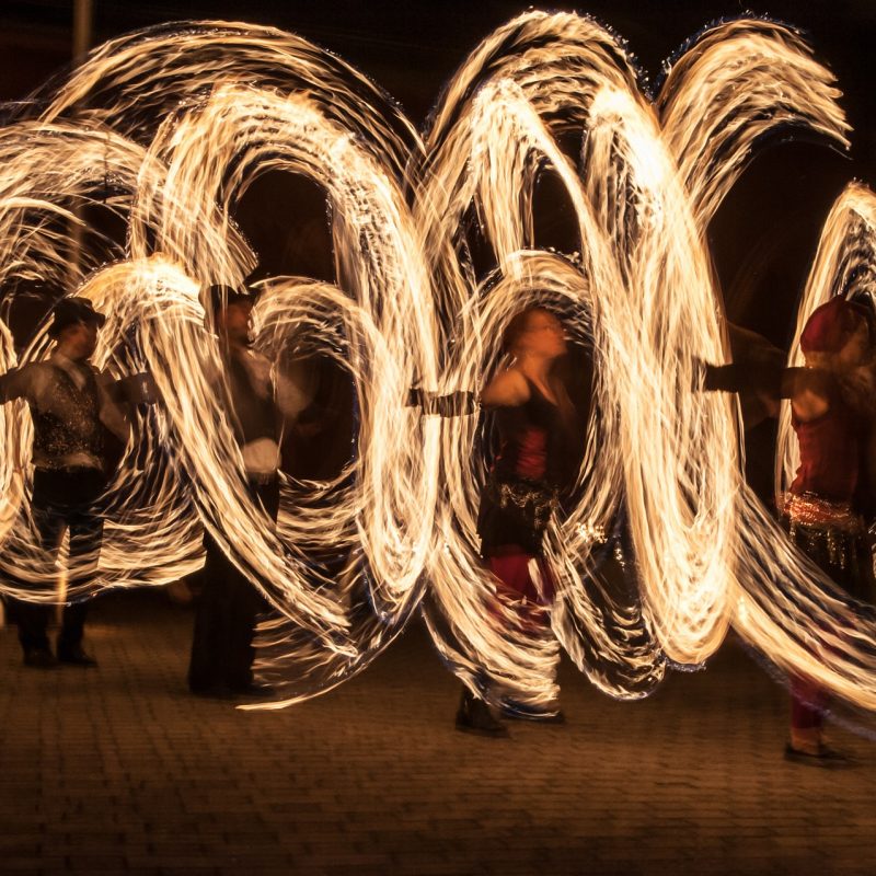 Juggling fire poi dancers