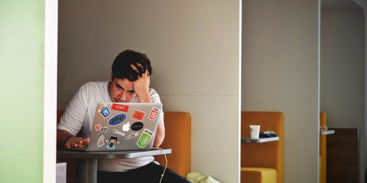 man looking frustrated whilst working on laptop