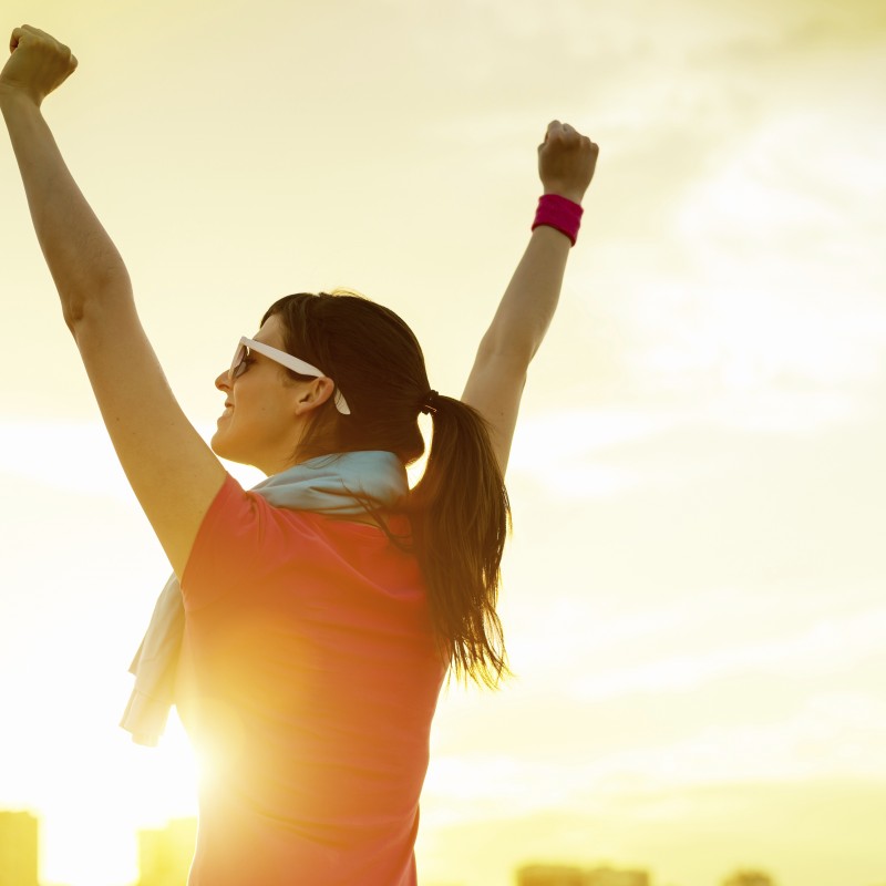 Sportswoman with arms up celebrating success