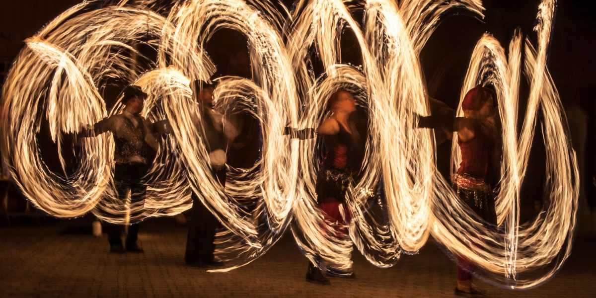 Juggling fire poi dancers